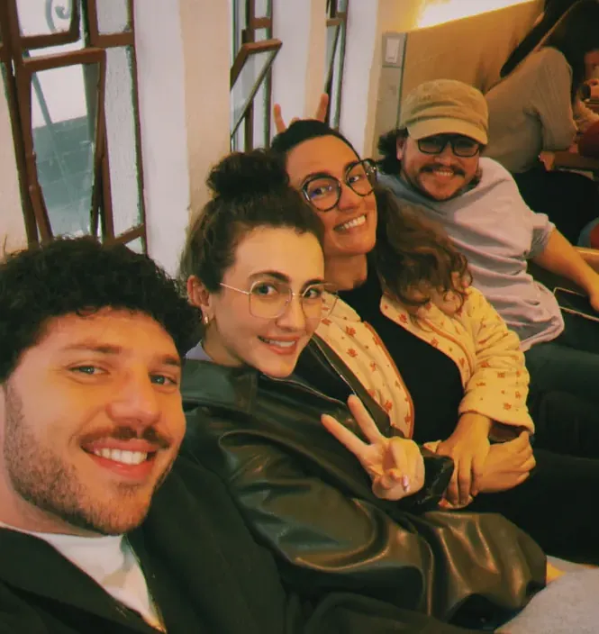 Leo com a família reunida à noite, sorrindo para a câmera